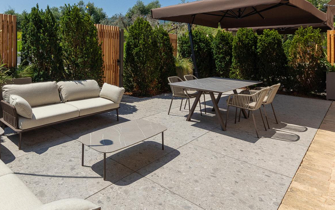 Zdjęcie przedstawia ogród wraz ze stołem dostępnym w sklepie Furnigo.